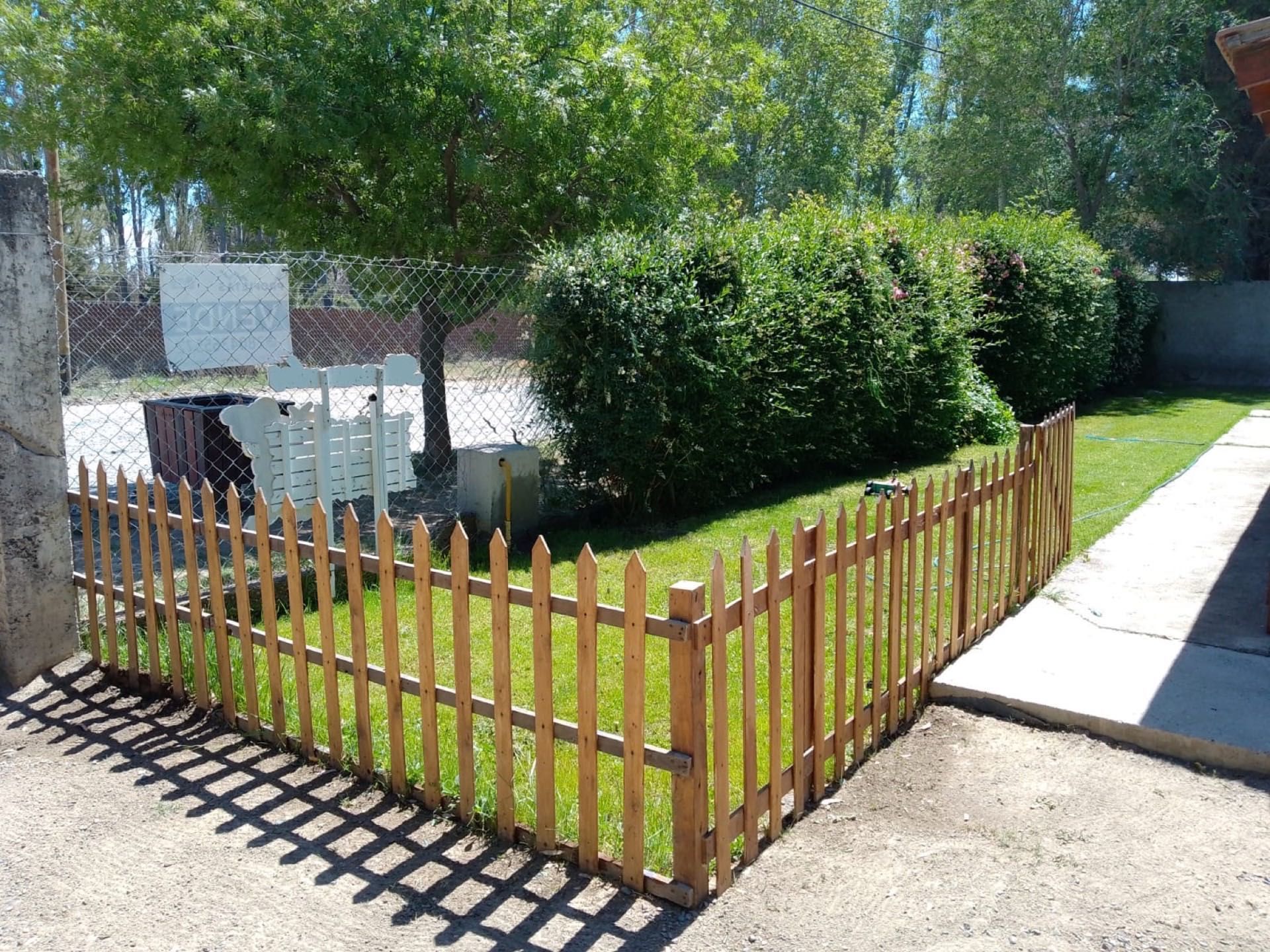 Cerquita de madera junto al cerco vivo y la vereda