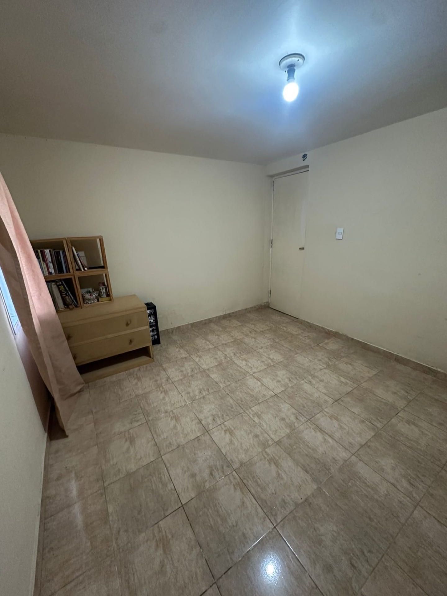 Ambiente con biblioteca y piso cerámico